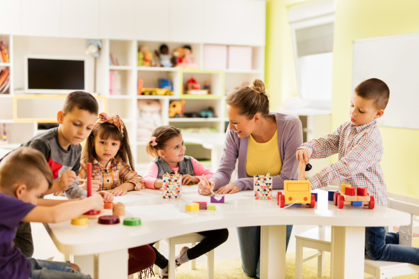 A group of children playing with toys in a classroom.